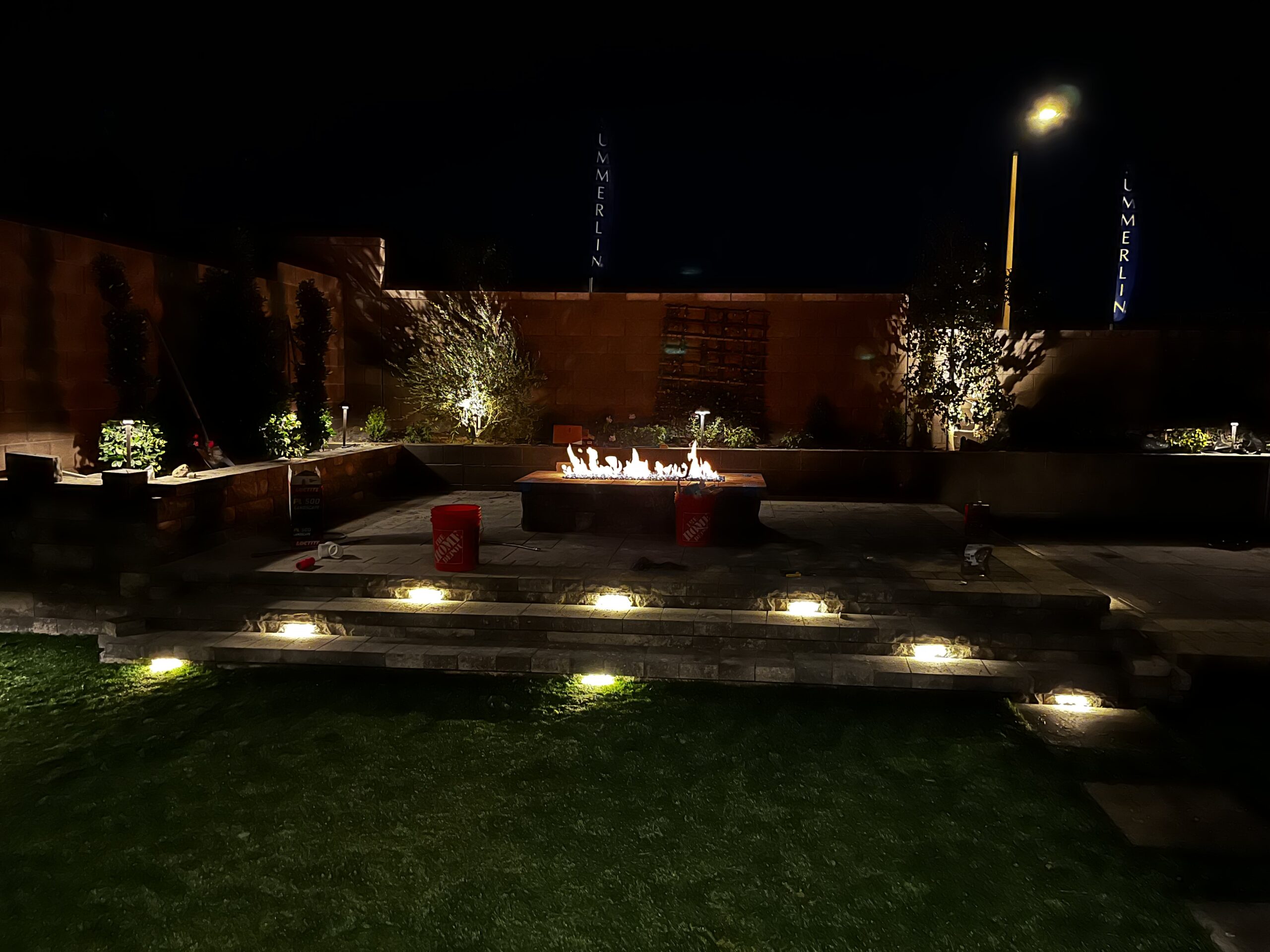 A firepit sits on a newly built, raised patio